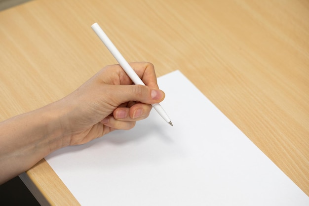 Zbliżony i szczegółowy widok na rękę i ramię białego człowieka trzymającego pióro do pisania