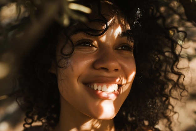 Zbliżony portret pięknej afroamerykańskiej kobiety z kręconymi włosami uśmiechającej się