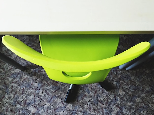 Zdjęcie zbliżony widok zielonego krzesła przy stole