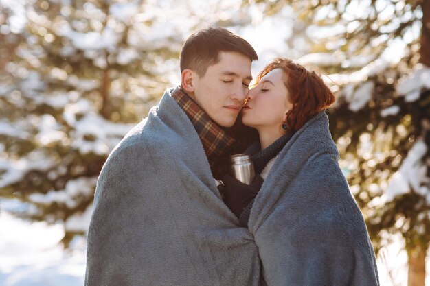 Zbliżony zdjęcie młodej zakochanej pary w środku śnieżnego lasu małżeństwo stoi
