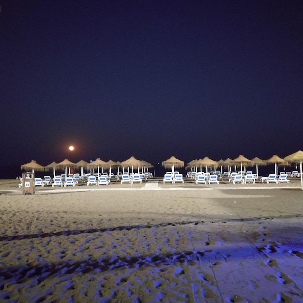 Zbudowana budowla na plaży na tle jasnego niebieskiego nieba w nocy