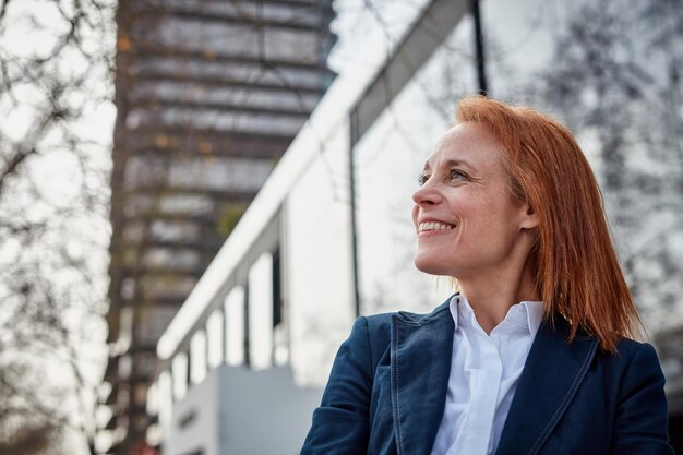 Zdecydowana bizneswoman w średnim wieku uśmiecha się, budując swoją historię sukcesu
