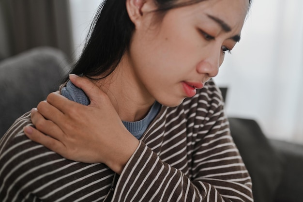 Zdjęcie zdenerwowana młoda kobieta dotykająca szyi cierpiąca na ból i napięcie opieka zdrowotna i koncepcja problemu
