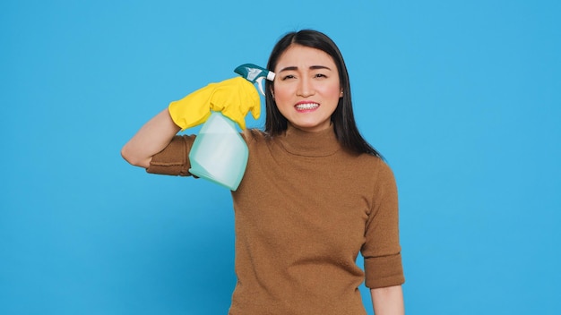 Zdenerwowana Wściekła Pokojówka Kładzie Detergent W Sprayu Przed świątynią, Udając, że Zastrzeliła Się Po Zakończeniu Sprzątania Domu Klienta. Sprzątaczka Nosiła Rękawiczki Podczas Wykonywania Prac Domowych