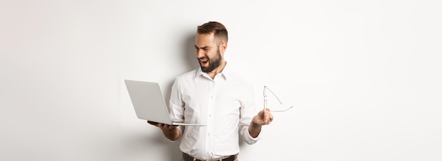 Zdezorientowany Menedżer Patrzący Na Laptopa Stojącego Rozczarowany Na Białym Tle