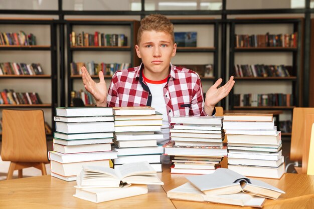 Zdezorientowany Nastoletni Chłopak Siedzi W Bibliotece