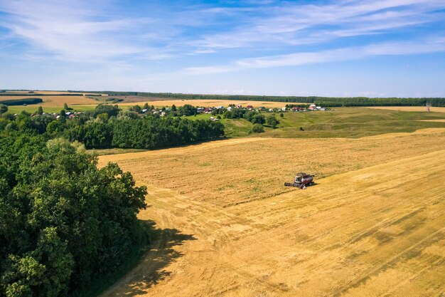 Zdjęcia lotnicze - kombajn zbożowy pracujący w polu pszenicy.