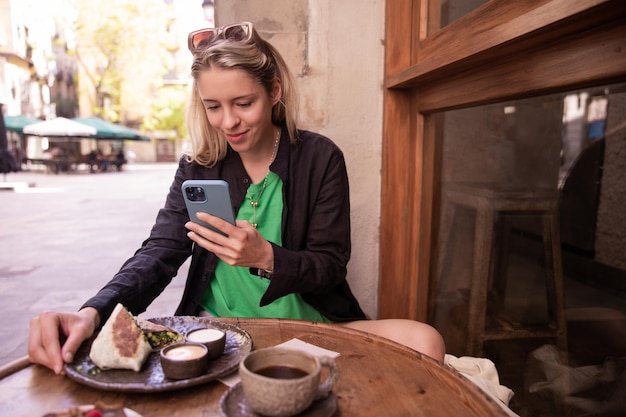 Zdjęcie Blondynki W Kawiarni Trzymającej Telefon