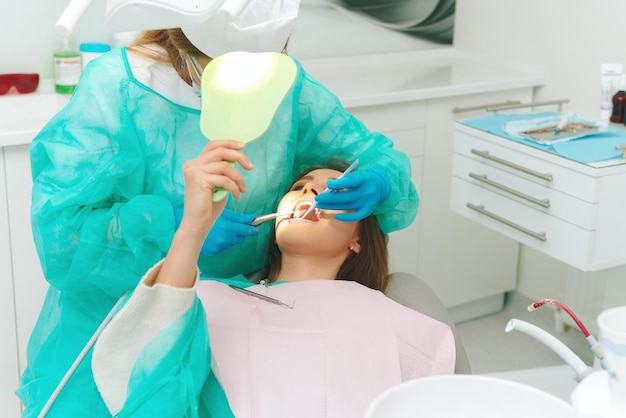 Zdjęcie dentystki i jej pacjenta w trakcie badania zębów