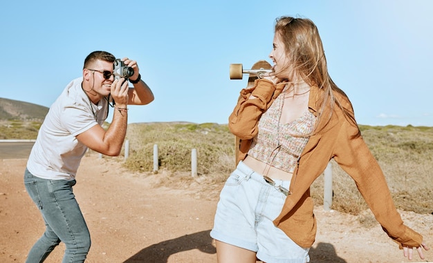 Zdjęcie deskorolka i para na wycieczce na łonie natury, aby podróżować latem Fotograf miłość i mężczyzna z zabytkowym aparatem i zdjęciem influencera gotowego do jazdy na deskorolce na wsi