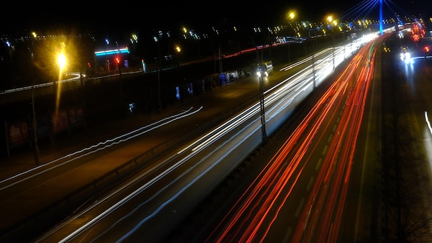 Zdjęcie długiej ekspozycji świateł samochodowych na drodze w nocy