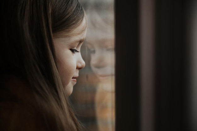 Zdjęcie dziewczyny wyglądającej przez okno