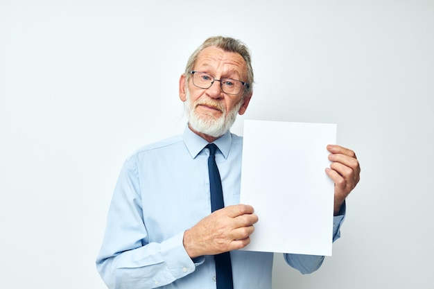 Zdjęcie emerytowanego starca trzymającego dokumenty z arkuszem papieru w jasnym tle