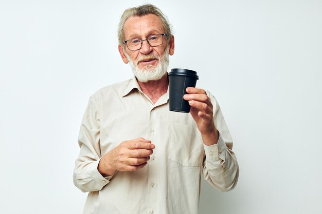 Zdjęcie emerytowanego staruszka z siwą brodą w jasnej koszuli i okularach