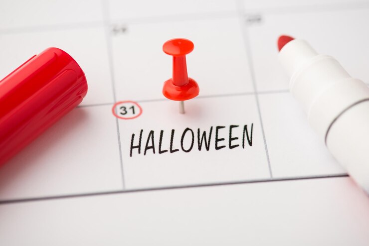 Zdjęcie zdjęcie etykiety z datą 31 października napis halloween czerwony pin i znacznik na białym tle na tle kalendarza