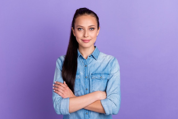 Zdjęcie fajnej, atrakcyjnej, przyjaznej, uśmiechniętej kobiety, skrzyżowanej, w dobrym nastroju, ubranej w swobodną koszulę, na białym tle w fioletowym kolorze