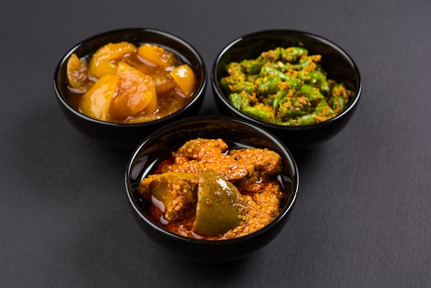 Zdjęcie grupowe indyjskich marynat, takich jak marynata z mango, ogórek cytrynowy i zielona marynata chili, serwowana w czarnej ceramicznej misce, selektywne skupienie