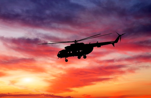 Zdjęcie helikoptera o zachodzie słońca. Sylwetka helikoptera na zachód słońca niebo.