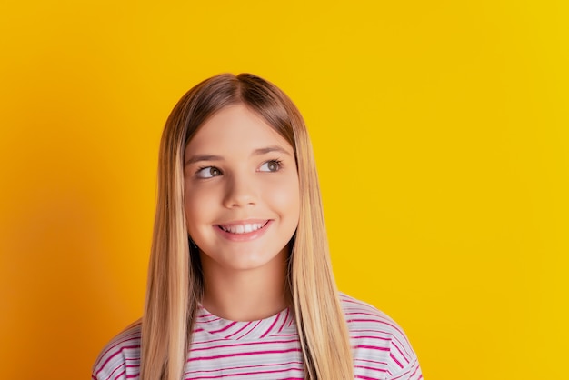 Zdjęcie inspirowanej dziewczynki, która myśli, że wygląda na copyspace na żółtym tle