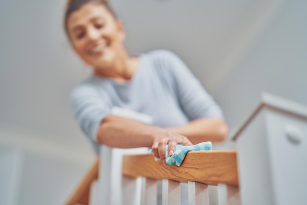 Zdjęcie kobiety czyszczącej stopnie schodowe lub balustradę