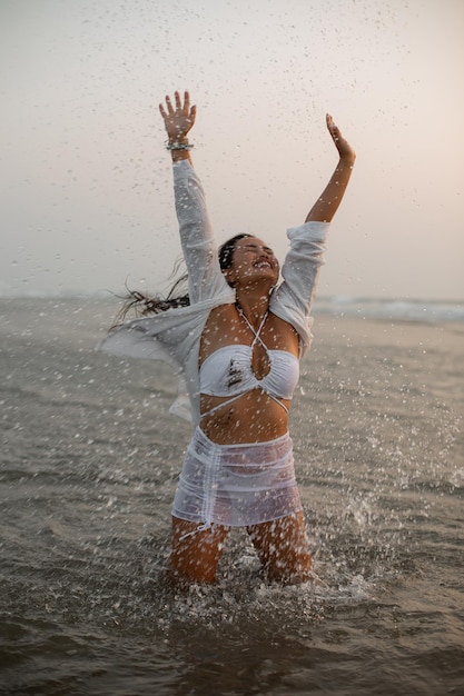 Zdjęcie zdjęcie kobiety z uśmiechem, wolnością i szczęściem na plaży, cieszącej się podróżami oceanicznymi, wakacjami