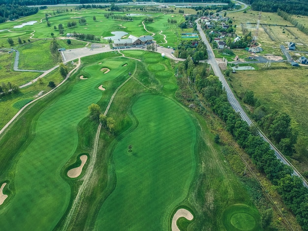 Zdjęcie lotnicze klubu golfowego, zielonych trawników, drzew, dróg, kosiarek,