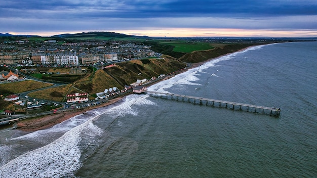 Zdjęcie lotnicze molo przybrzeżnego miasta i fal oceanicznych w Saltburn by the Sea