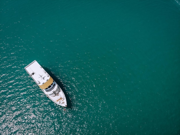 Zdjęcie lotnicze odosobnionego jachtu z brązowym drewnianym wzorem na morzu. Morze Andamańskie