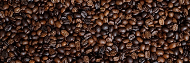 Zdjęcie makro z bliska tekstury palonych ziaren kawy ciemne może służyć jako tło