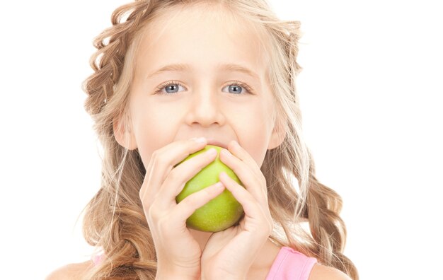 zdjęcie małej dziewczynki z zielonym jabłkiem