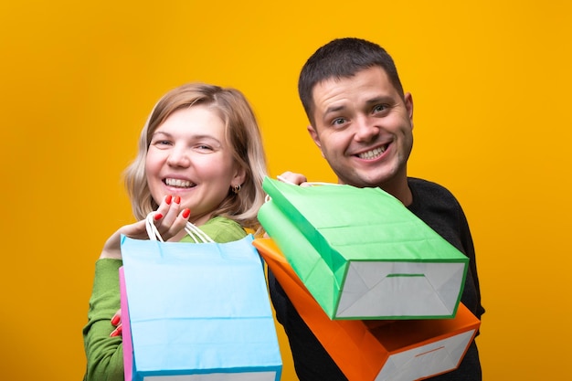 Zdjęcie mężczyzny i kobiety z wielokolorowymi torbami na zakupy