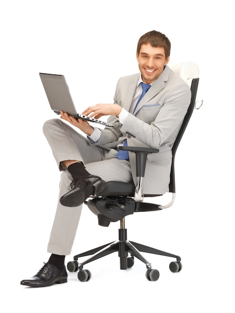 zdjęcie młodego biznesmena siedzącego na krześle z laptopem