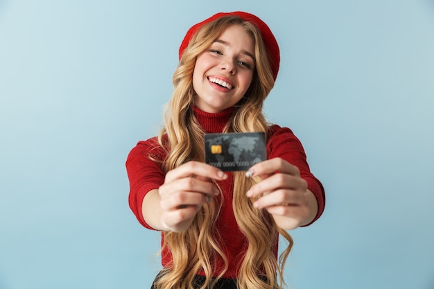 Zdjęcie Piękne 20s Blond Kobieta Ubrana W Czerwony Beret Trzymając Kartę Kredytową Na Białym Tle
