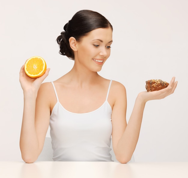 zdjęcie pięknej kobiety z ciastem i pomarańczą