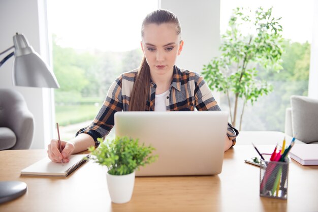 Zdjęcie zdjęcie pięknej studentki przeglądającej notebook netbook edukacja przepustka sesyjna zadania w pomieszczeniu