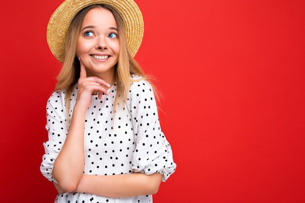 Zdjęcie portret młodej pięknej ślicznej szczęśliwej blondynki ubranej na co dzień w sukienkę i słomkowy kapelusz