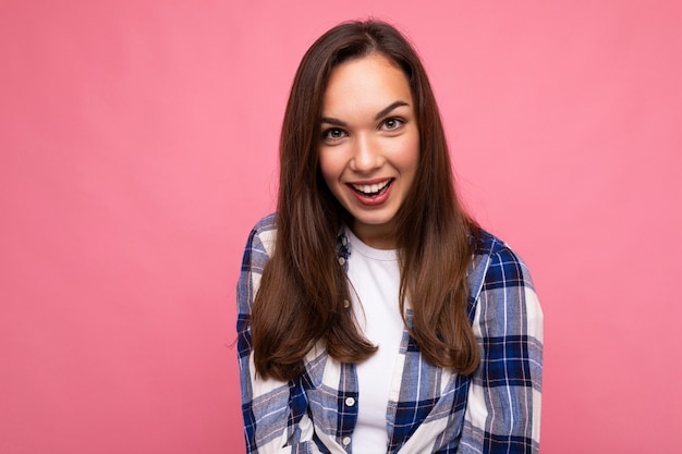 Zdjęcie portret młodej pięknej uśmiechniętej brunetki hipster w modnej niebiesko-białej koszuli i