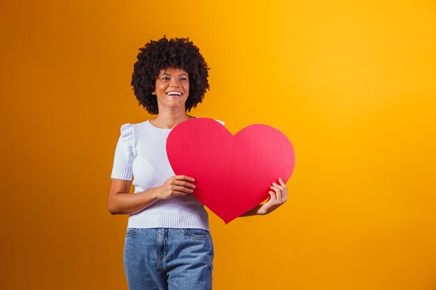 Zdjęcie Portret Uśmiechniętej Kobiety Afro Trzymającej Dużą Czerwoną Kartkę Serca