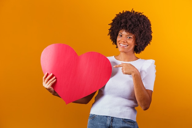 Zdjęcie Portret Uśmiechniętej Kobiety Afro Trzymającej Dużą Czerwoną Kartkę Serca