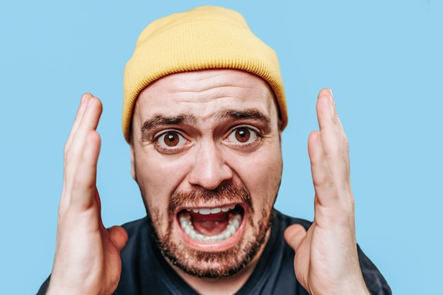 Zdjęcie portretowe krzyczącego mężczyzny, którego twarz wykrzywił grymas