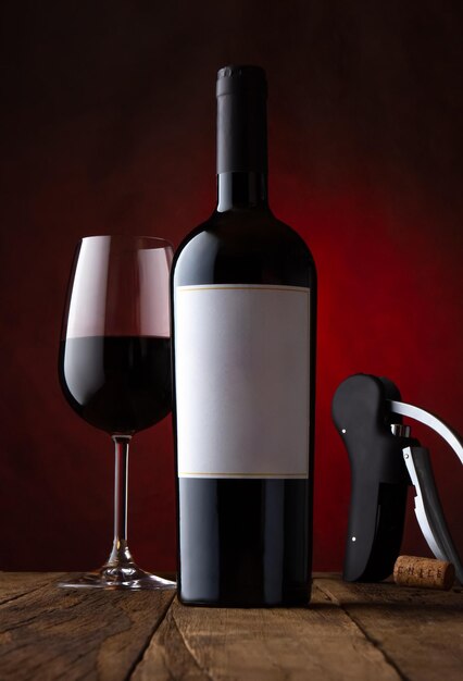Zdjęcie zdjęcie promocyjne szkła i butelki czerwonego wina z pustą etykietą z rdzawo-brązowym wzorem tła