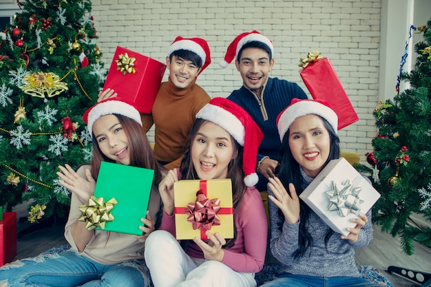 Zdjęcie przedstawia grupę azjatyckich przyjaciół świętujących Boże Narodzenie w domu.