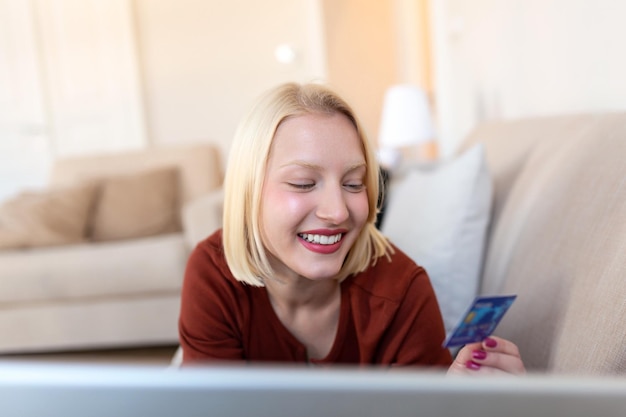 Zdjęcie zdjęcie przedstawiające ładną kobietę robiącą zakupy online za pomocą karty kredytowej kobieta trzymająca kartę kredytową i używająca laptopa koncepcja zakupów online