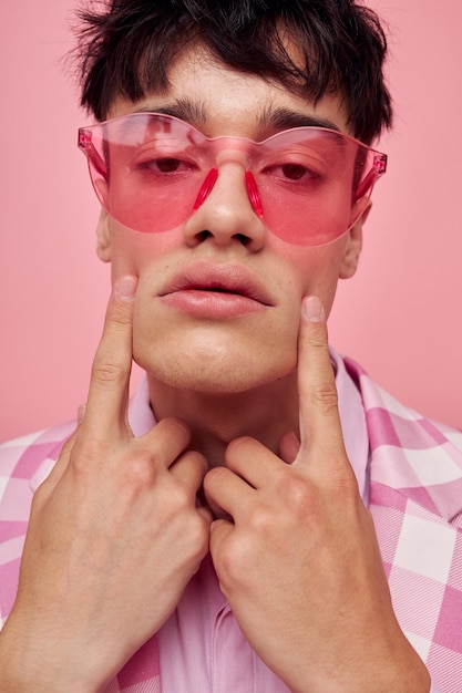 Zdjęcie romantycznego młodego chłopaka modne różowe okulary przeciwsłoneczne kurtka pozuje model studio