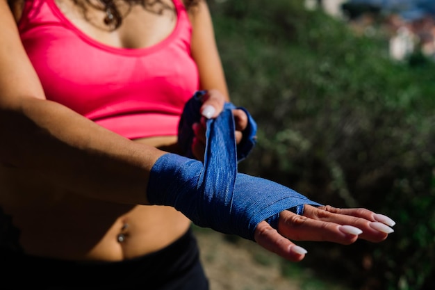 Zdjęcie silnej kobiety bokser fitness w rękawiczkach pozowanie na zewnątrz.