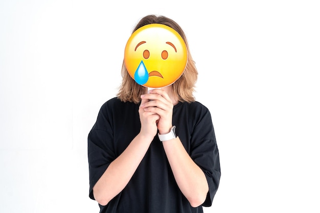 Zdjęcie zdjęcie smutnej, słodkiej, miłej, smutnej, zdesperowanej dziewczyny na twarzy odzwierciedlającej jej stan wewnętrzny za pomocą emoji