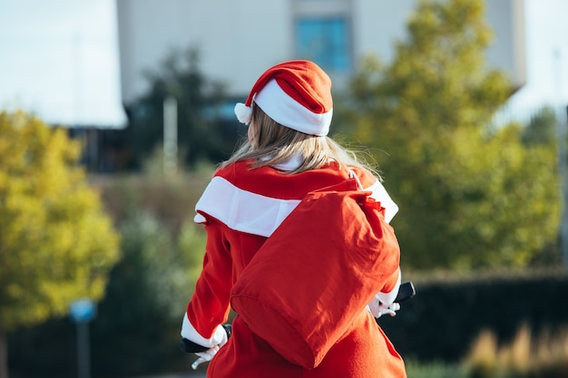 Zdjęcie stockowe przedstawiające Mama noel z powrotem do ulicy, jazda na rowerze. czas świąt