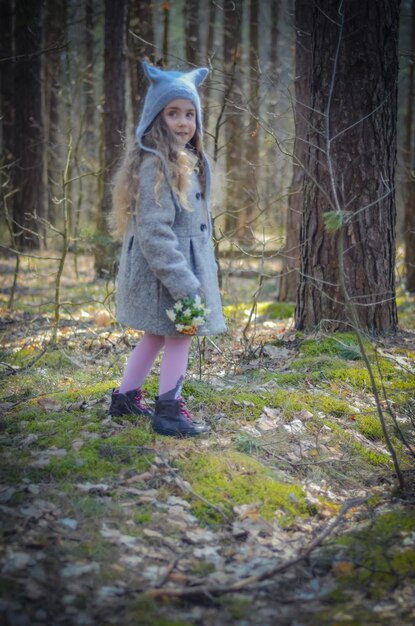 Zdjęcie zdjęcie styl vintage ubrana mała dziewczynka gra w lesie