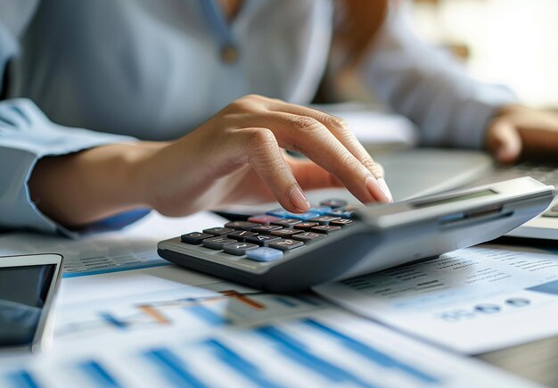 Zdjęcie trzymającego kalkulator w ręku sprawdzającego zyski firmy, zarządzającego rachunkiem dochodowym