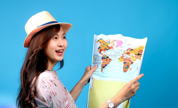 zdjęcie turystki pod ręką mają mapę szczęśliwej podróży na niebieskim tle